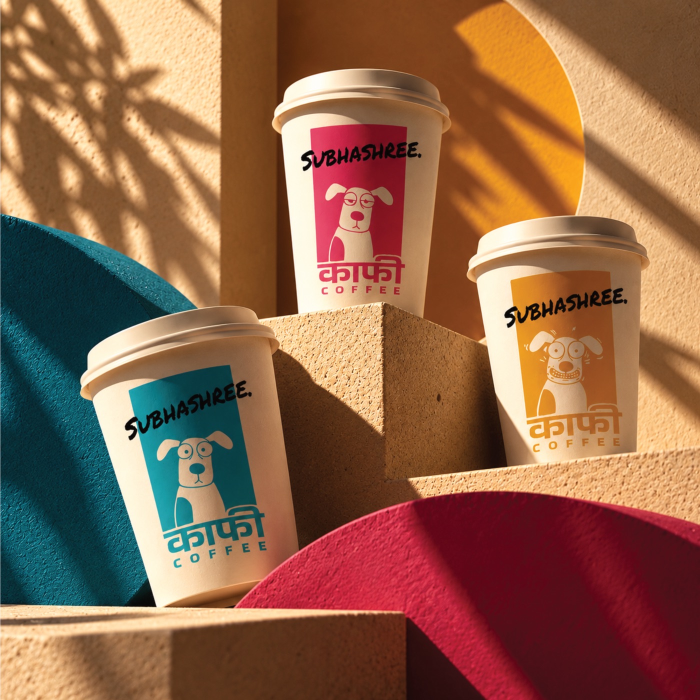 Three Kaafi Coffee cups in teal, pink and yellow