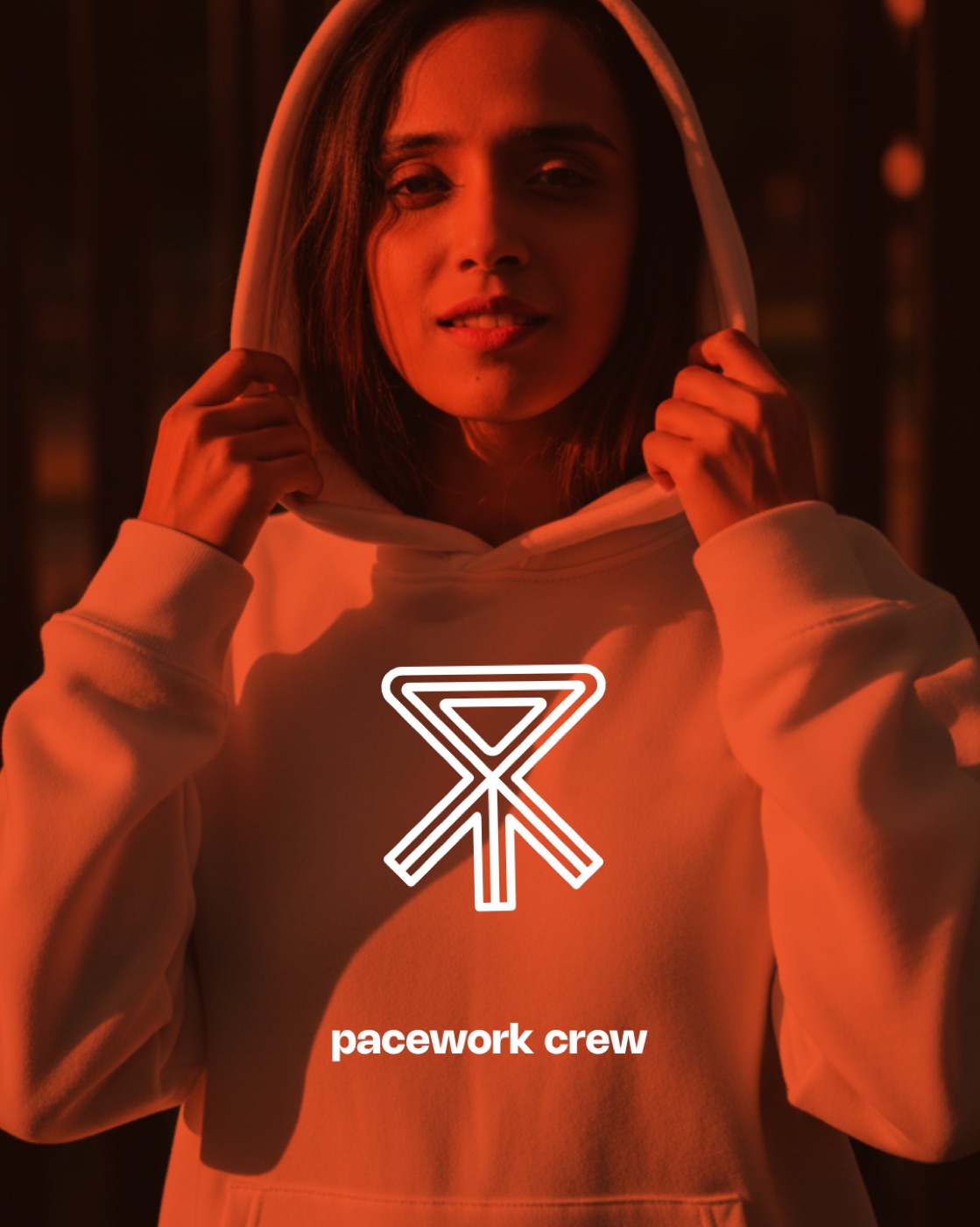 A runner in an orange Pacework Crew hoodie with the club's ribbon-arrow mark on the chest